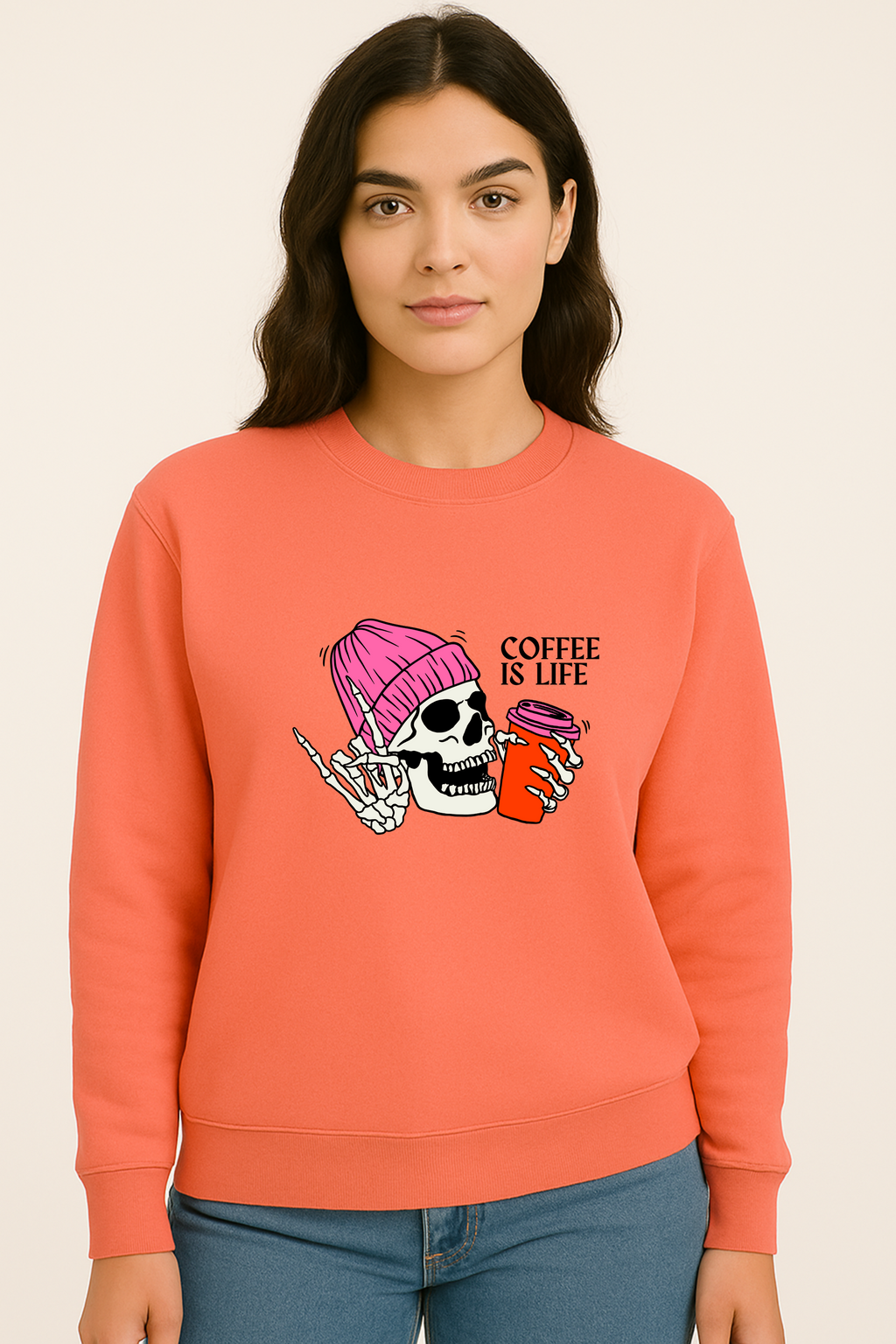 Person wearing a coral sweatshirt with a graphic design on a beige background