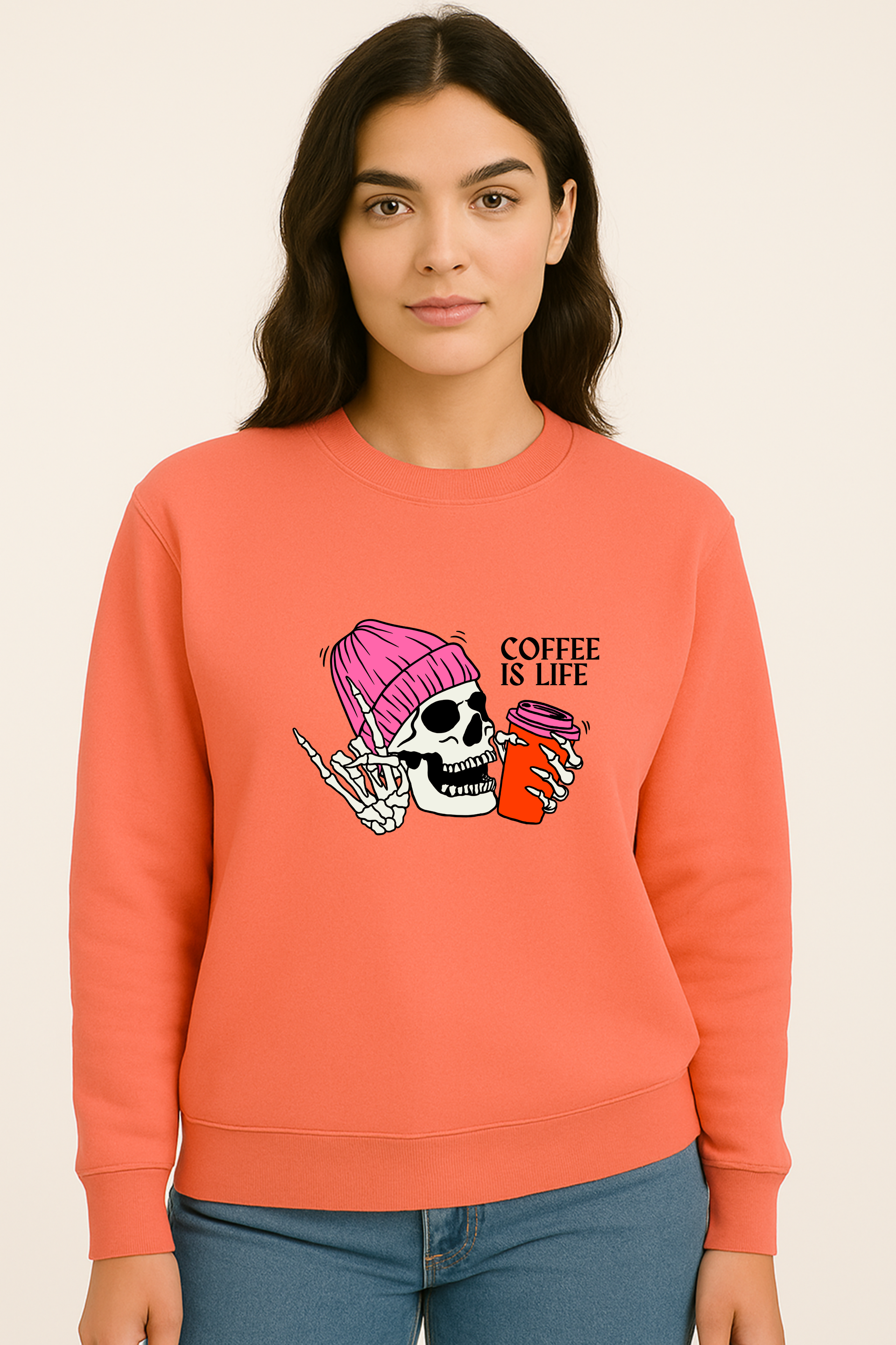 Person wearing a coral sweatshirt with a graphic design on a beige background